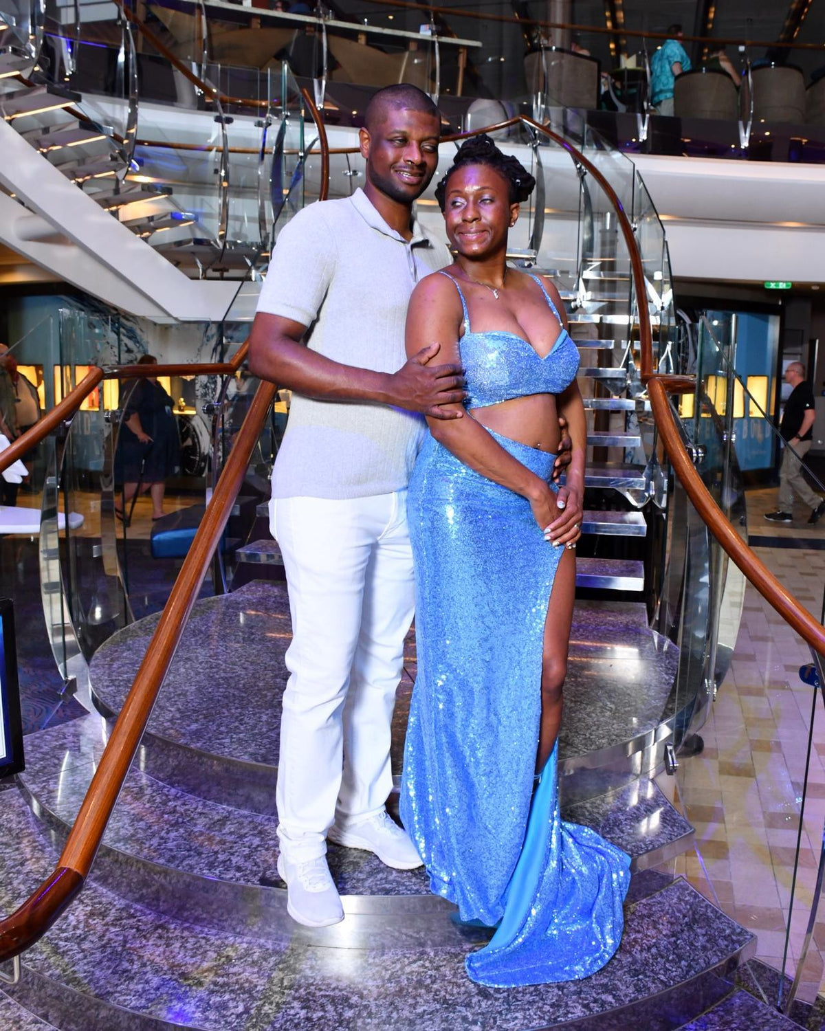 Kevin and Jasmine dressed up on a grand curved staircase for formal night on a family cruise in 2026.